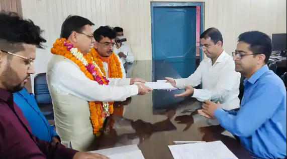 धामी ने भरा अपना नामांकन